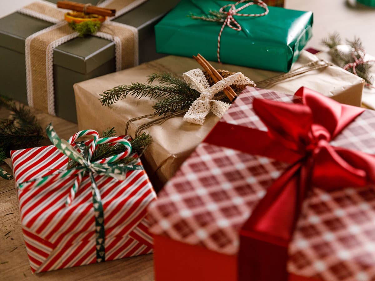 A table covered with numerous wrapped presents in various colors and sizes, ready for a celebration